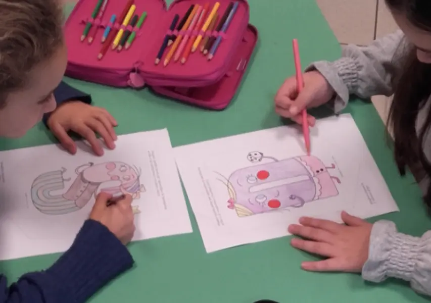 <p>Bambini di una scuola elementare che colorano i festoni Alfabelli.</p>